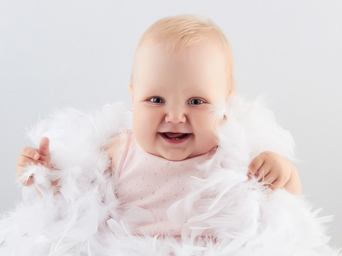 Baby smiling with white feathers