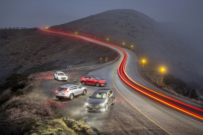 Mazda CX-9s on a foggy mountain road at night