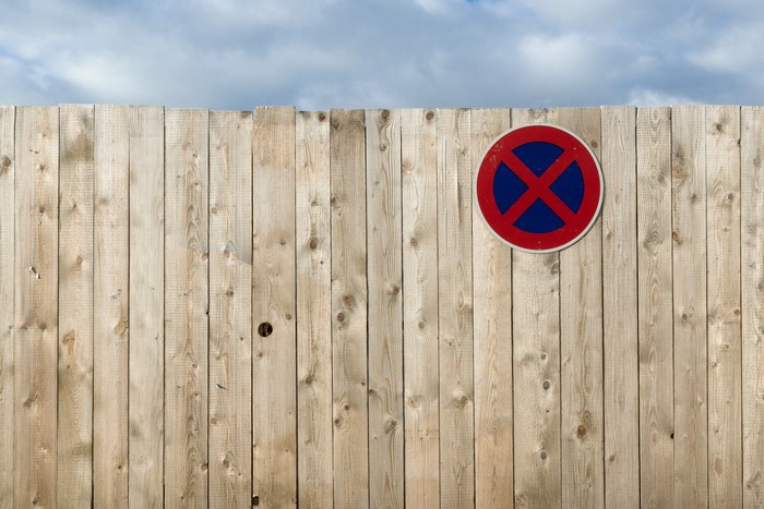 No parking sign on a wooden fence