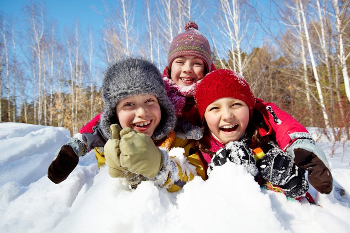 Three happy children in the snow