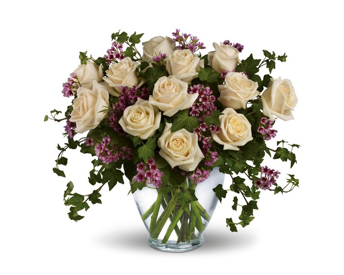 White roses in a glass vase with ivy and pink flowers