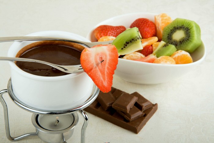 Chocolate fondue with strawberries, kiwi, and tangerines