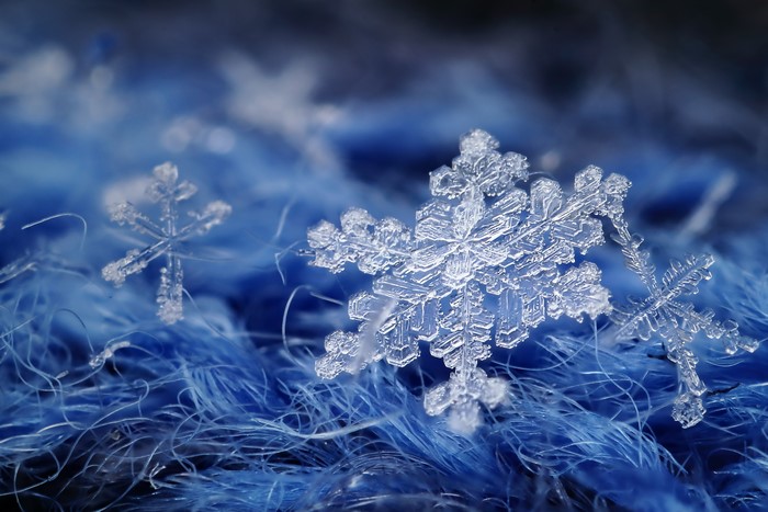 Macro view of snowflakes on blue fabric