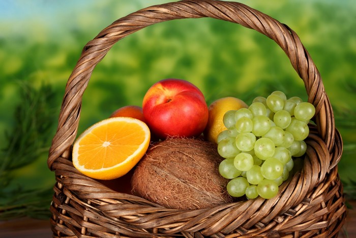 Fruit basket with grapes, apple, orange, and coconut