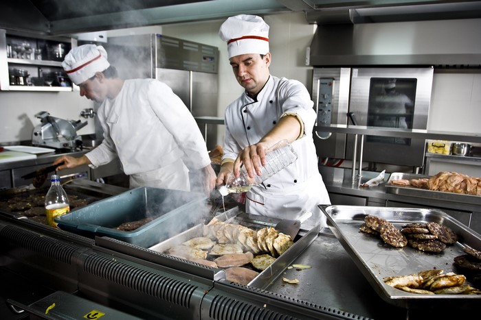 Two chefs cooking in a professional kitchen