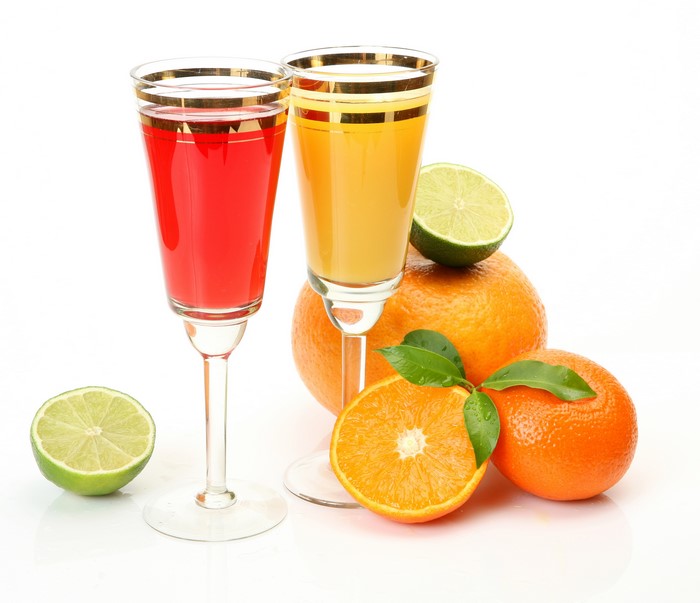Two glasses of juice with oranges and limes