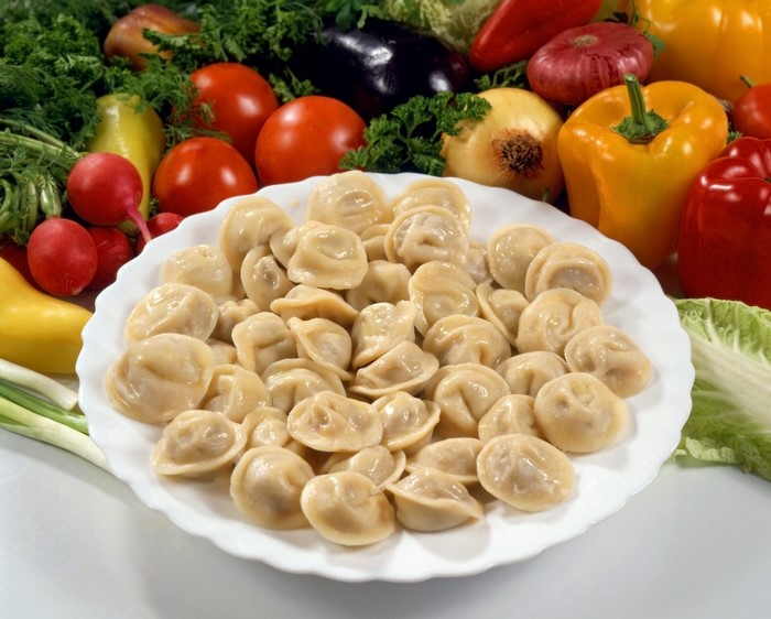 Pelmeni on a plate with vegetables