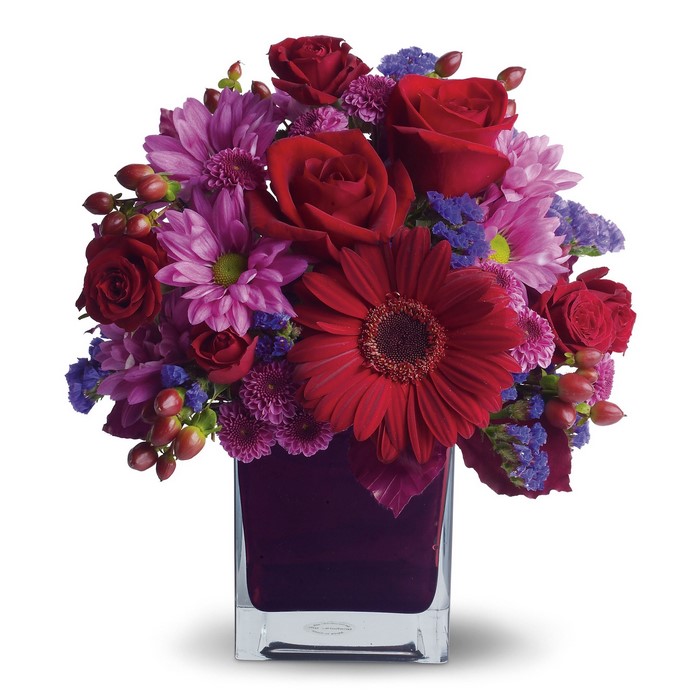 Red and purple flower arrangement in a square vase