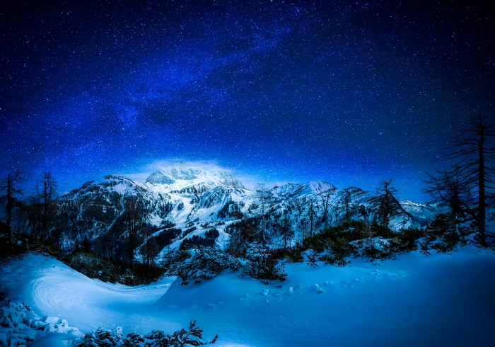 Snowy mountains under a starry night sky