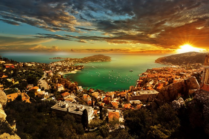 French Riviera coast with houses and boats at sunset