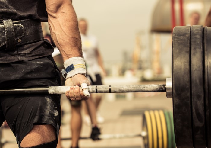 Weightlifter gripping a barbell with heavy weights