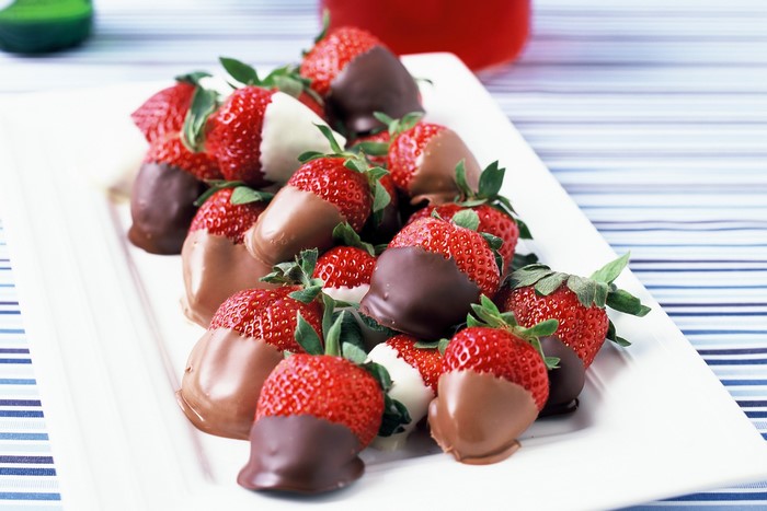 Chocolate-dipped strawberries on a white platter