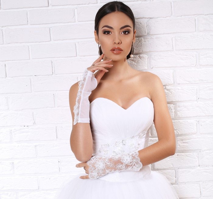 Bride in white dress with lace gloves