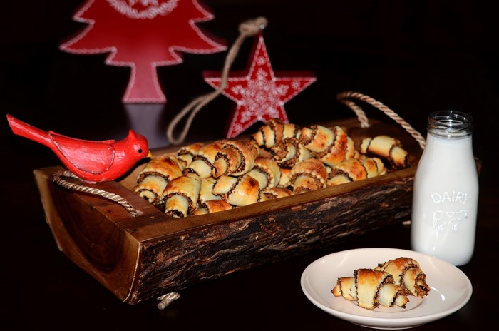 Rugelach pastries in a wooden tray with milk