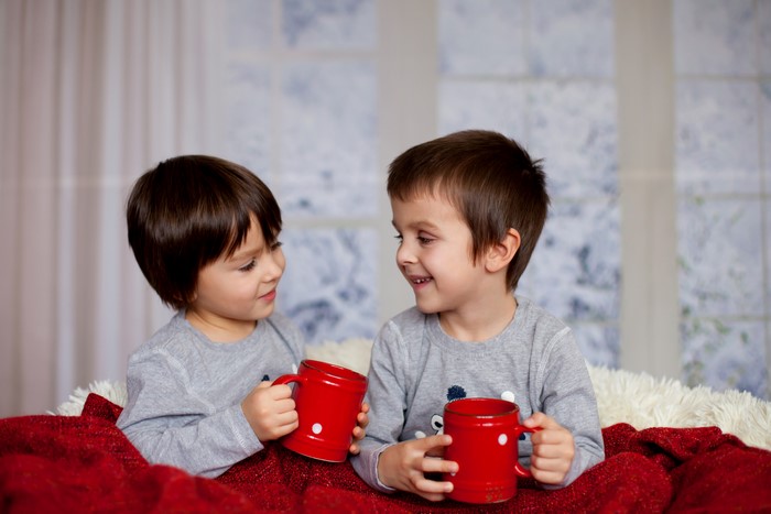 Two Boys Holding Red Mugs