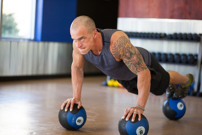 Man doing push-ups on medicine balls