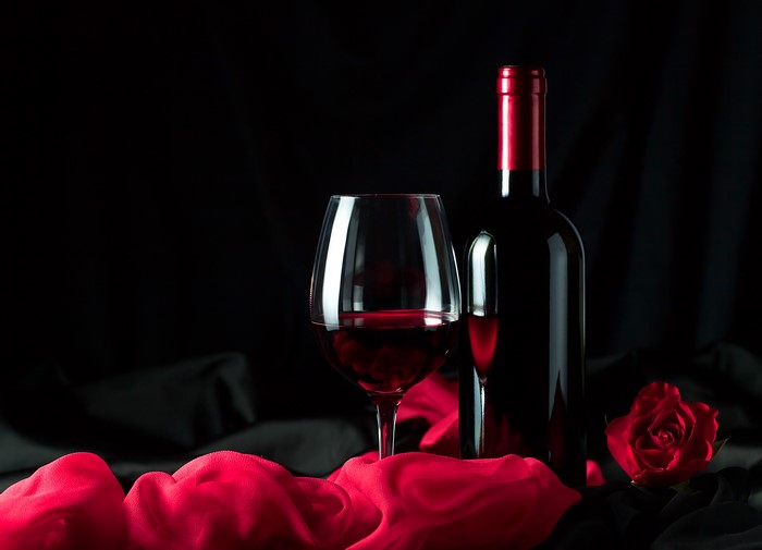 Wine bottle and glass with red rose