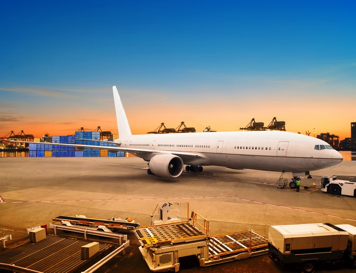 Airplane at a cargo port at sunset