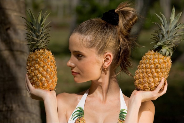 Woman holding two pineapples