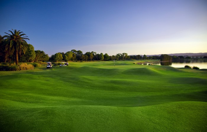 Golf course with rolling green hills and a lake