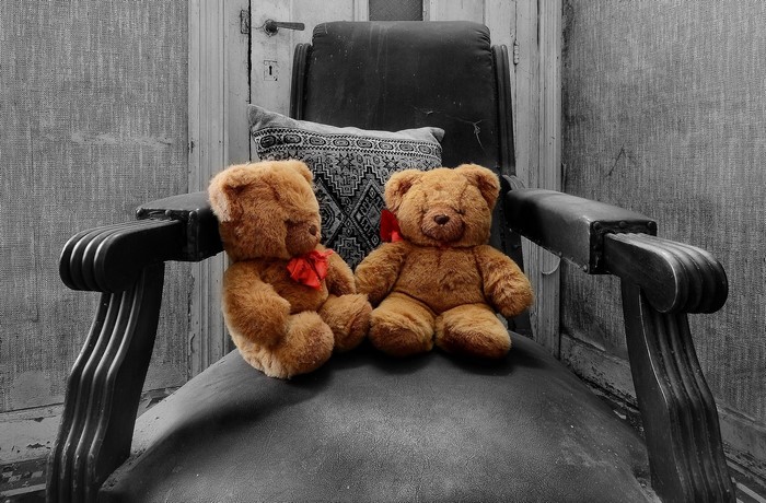 Two teddy bears sitting on an armchair