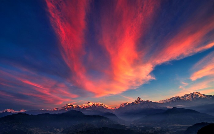 Dramatic sunset over snow-capped mountains
