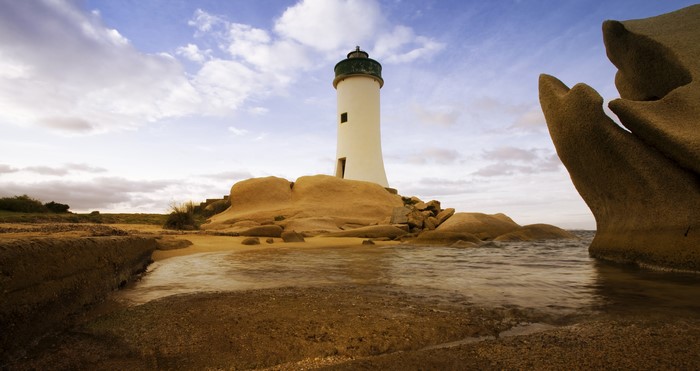 Lighthouse on rocky coast in Sardinia, Italy