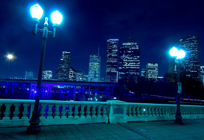 Houston skyline at night with street lights and fence