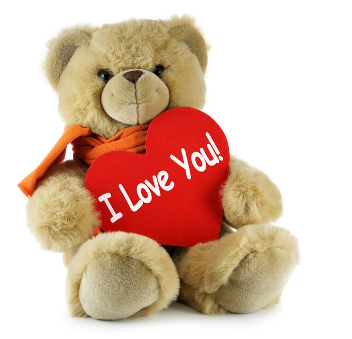 Teddy bear with orange scarf holding a red heart that says "I Love You!"