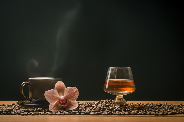 Coffee cup, orchid, and whiskey with coffee beans