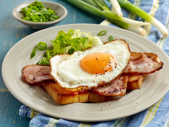 Fried egg with bacon and toast on a plate