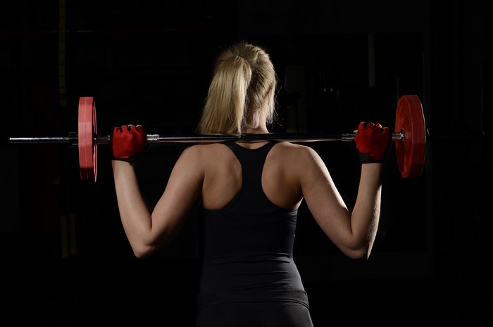Woman with barbell in gym