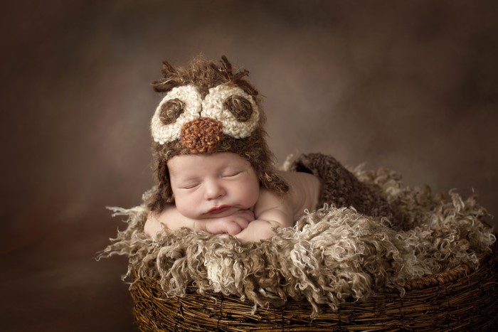 Newborn baby sleeping in owl hat
