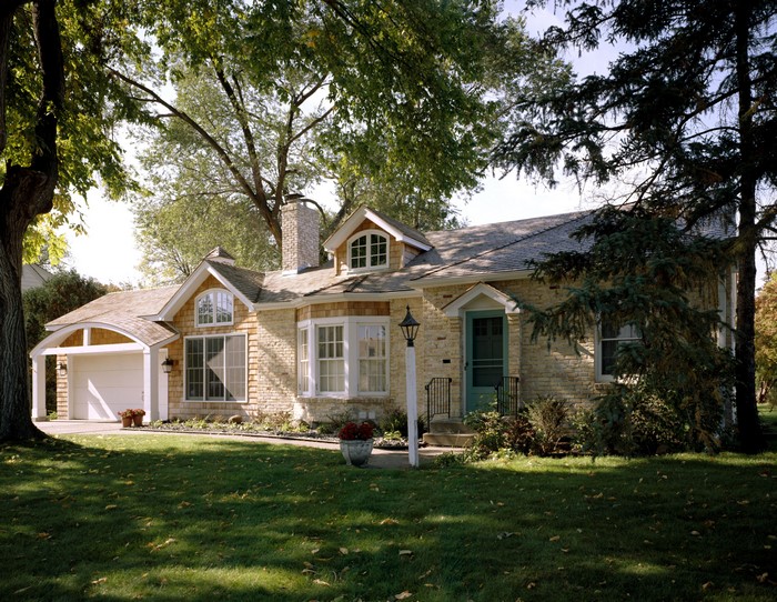 Stone house with garage and trees