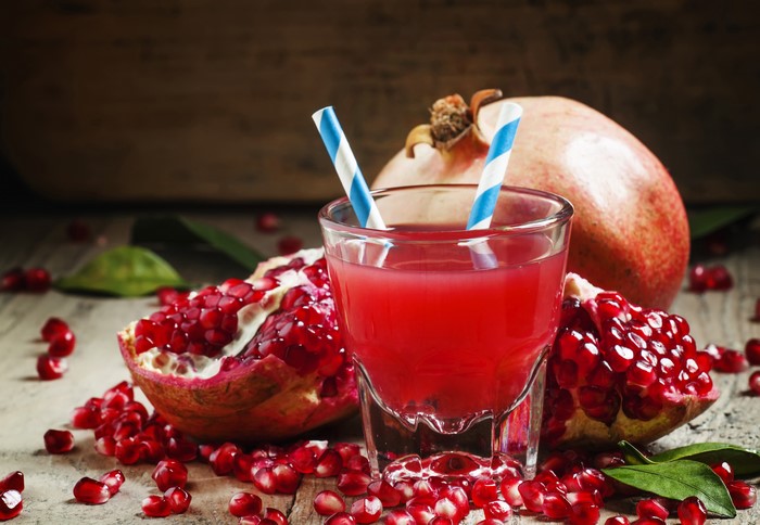 Pomegranate juice in a glass with pomegranates
