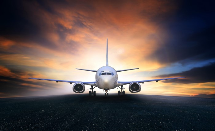 Airplane on runway at sunset
