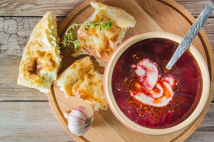 Borscht Soup with Bread and Garlic on a Cutting Board