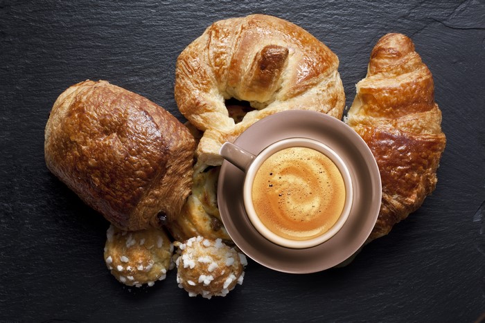 Croissants and Cappuccino on a dark surface