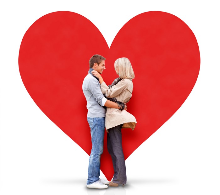 Couple hugging in front of a large red heart