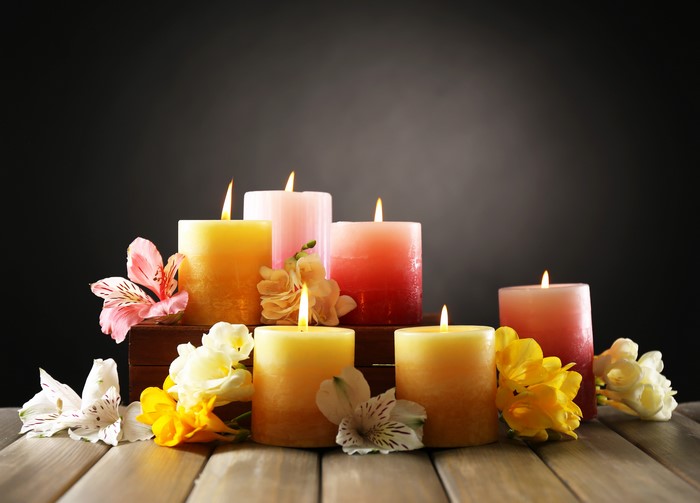 Candles with flowers on wooden table