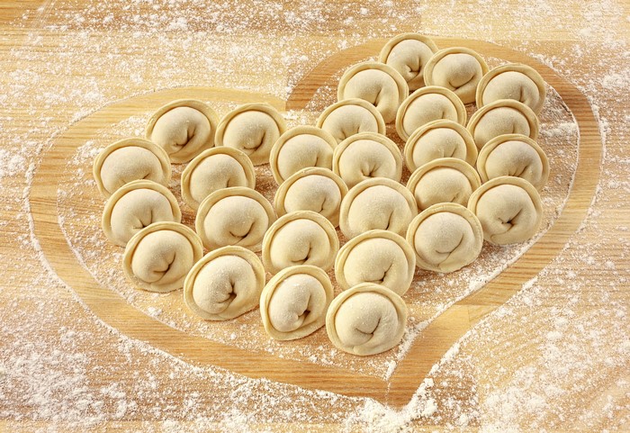 Pelmeni arranged in a heart shape with flour