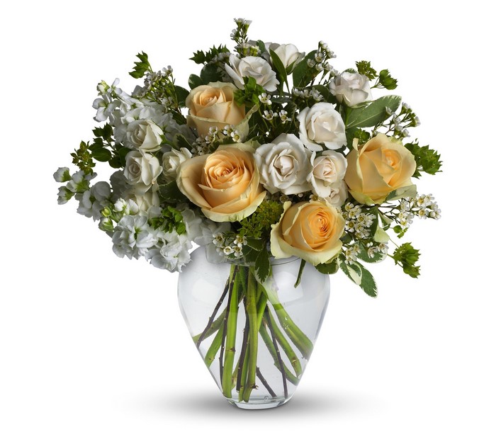 Peach and white roses in a glass vase
