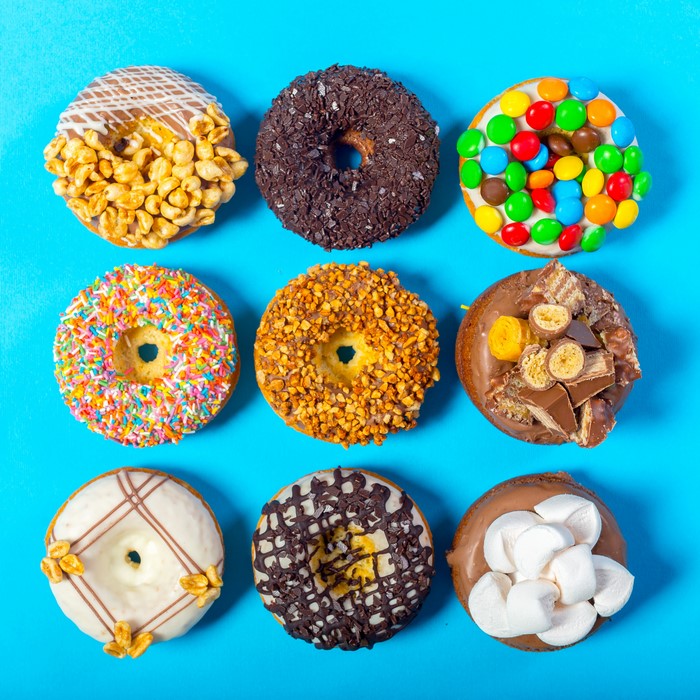 Nine assorted donuts on a blue background