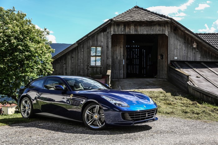 Blue 2016 Ferrari GTC4 Lusso parked near a wooden barn