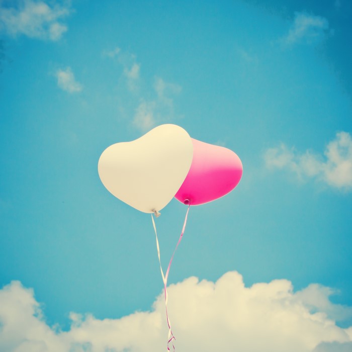 Two heart-shaped balloons in the sky