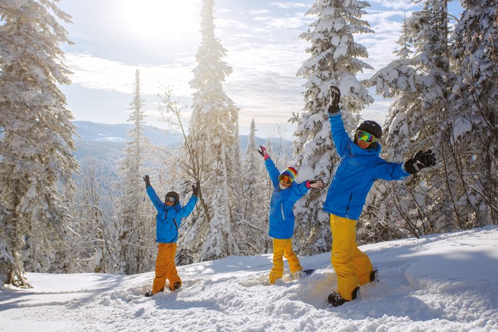 Three children in ski gear on a snowy mountain