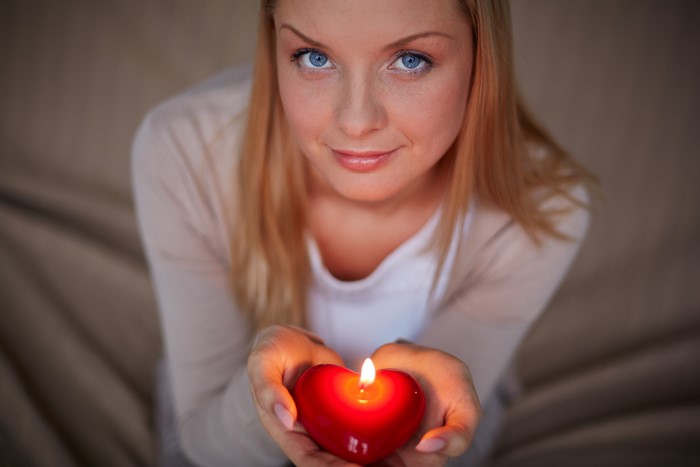 Woman holding a heart-shaped candle