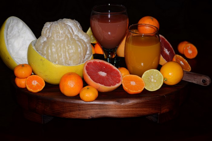 Citrus fruits and juices on a wooden platter