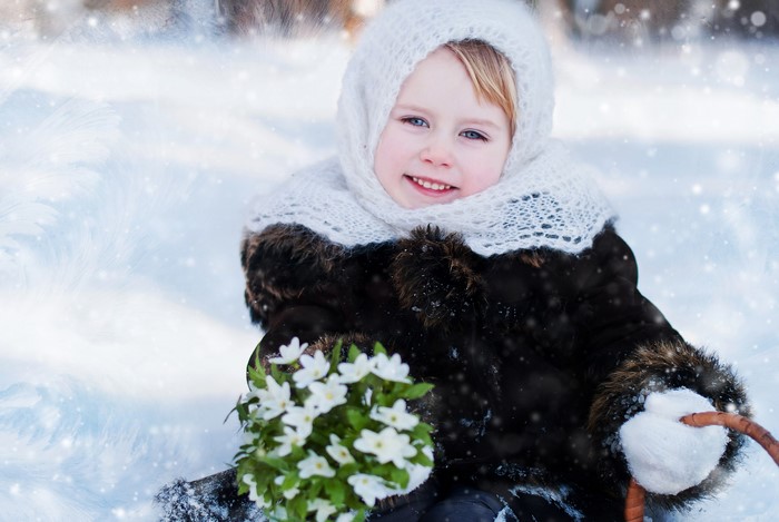 Girl in Winter Coat Holding Snowdrops