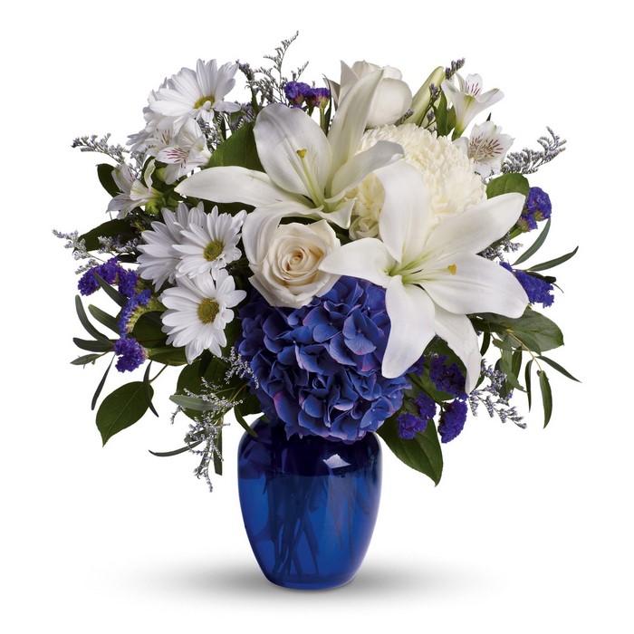 White and blue floral arrangement in a blue vase